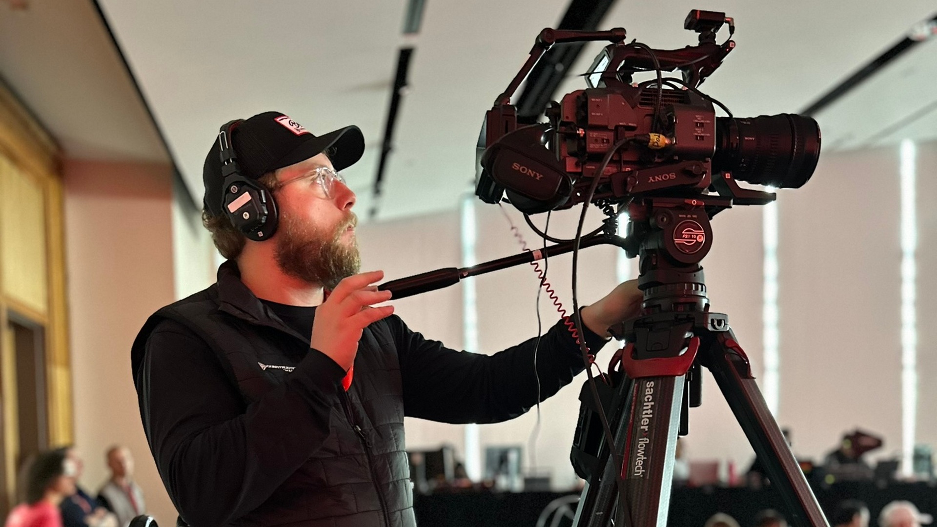 Camera operator filming at an indoor event